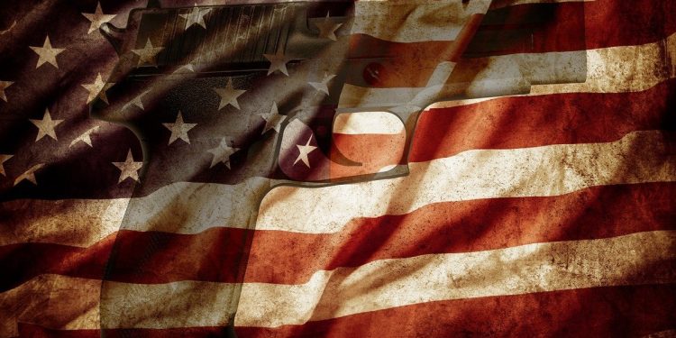 American flag, with a gun under it just visible