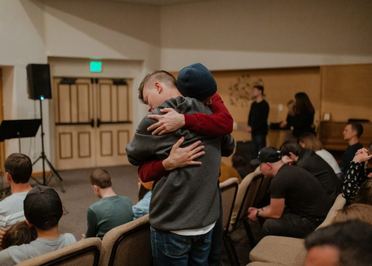 One person hugging another, who seems upset