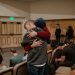 One person hugging another, who seems upset