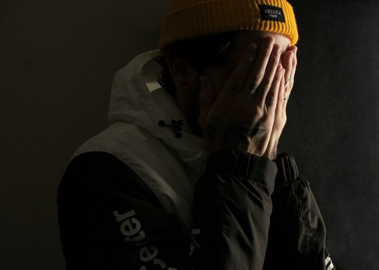 man covering his face with his hands
