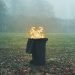 A burning wheelie bin in the middle of a field