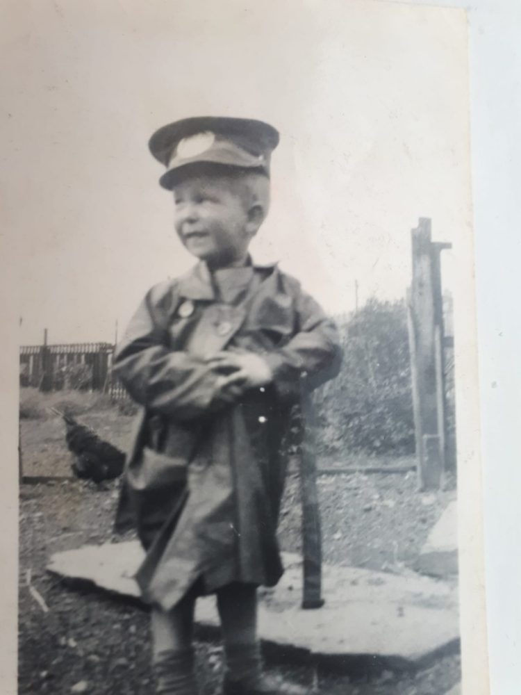 An old black and white photo of a young boy wearing a cap and jacket