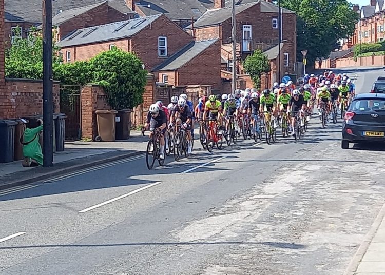 Large group of cyclists cycling on a street