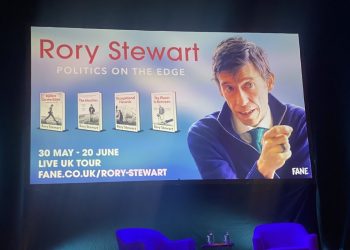 Two blue chairs at the bottom, and above a poster showing Rory Stewart and his books